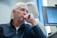 Man with gray hair sits in a doctor's office looking worried