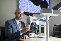 Pathologist Matthew Hanna in front of a microscope