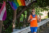 Sandy wearing an orange tank top and running.