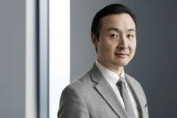 Medical oncologist Bob Li in front of a grey background