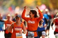 Two Fred’s Team runners wearing orange shirts in a crowd