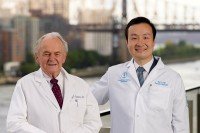 Sir Murray Brennan and Bob Li wearing white coats and posing for a photo outside