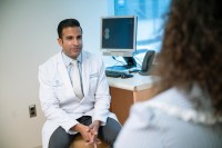 Breast cancer oncologist Neil Iyengar, MD, is seen talking with a patient. 