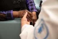 Detail shot of a nurse holding hands with a patient