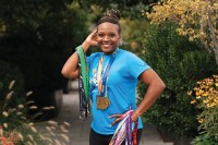 Breast cancer patient LaDawn Jefferson poses outside with her running medals
