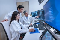 Dr. Nancy Lee, Dr. Alan Ho, and Dr. Richard Wong review scans on a computer