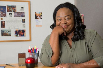 Breast cancer survivor Eutha Prince smiling for the camera in her office in West Harlem. She was treated at Memorial Sloan Kettering.