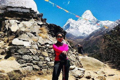 Manisha Koirala posing in hiking gear in front of Mount Everest.