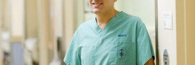 Ronald DeMatteo, Head of the Division of General Surgical Oncology at MSK, smiles at the camera while dressed in his scrubs.