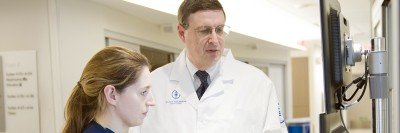 Jeffrey Drebin, Chair of the Department of Surgery at MSK, looks at computer screens with a female colleague.