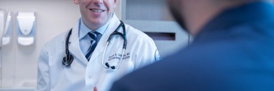 Doctor in white coat talking to a patient.