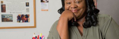 Breast cancer survivor Eutha Prince smiling for the camera in her office in West Harlem. She was treated at Memorial Sloan Kettering.