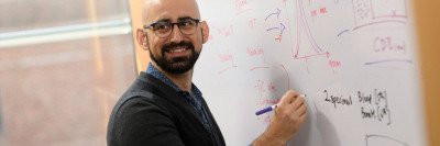 Bioinformatician Ahmet Zehir stands at a whiteboard
