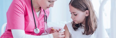 A nurse gives a girl a vaccination.