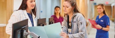 Two nurses talking at a desk