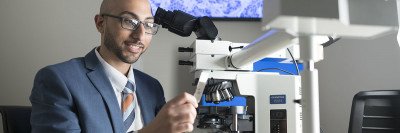 Pathologist Matthew Hanna in front of a microscope