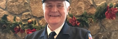 Older man in navy firefighter officer uniform.