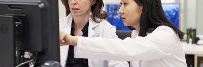 MSK medical oncologist, Dana Rathkopf, analyzing a computer screen with a female colleague