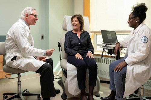 El oncólogo médico Dean Bajorin y la enfermera Asia McCoy se reúnen con un paciente con cáncer de vejiga
