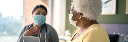 Elderly female patient talking to her doctor