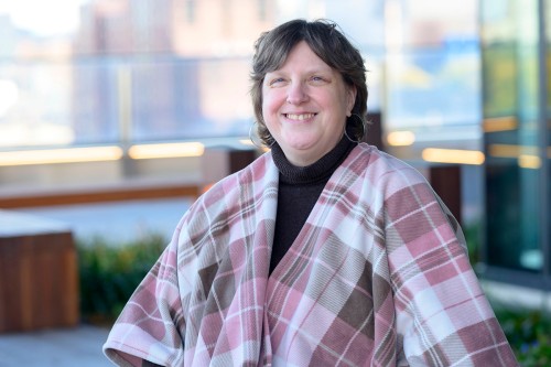 Pattie Fuller smiles while wearing a pink plaid poncho