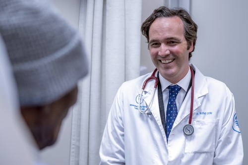 Dr. Bobby Daly seen smiling with patient. 