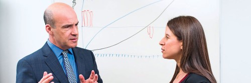 Man and woman talking in front of whiteboard
