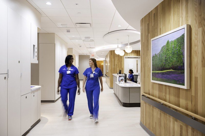 Two registered nurses walk down a hallway in a section that has 16 private inpatient rooms for people who need an overnight stay for treatment.
